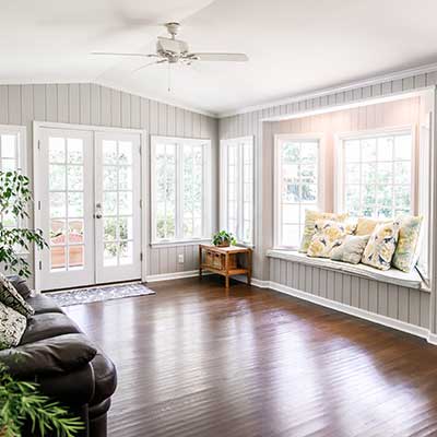 Modern, open living room space with lots of natural light coming in from its many large windows and its one double door