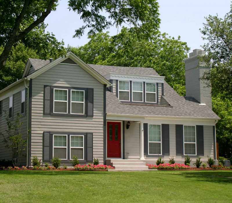 Front view of a smaller mid-class home with a gray shingle roof