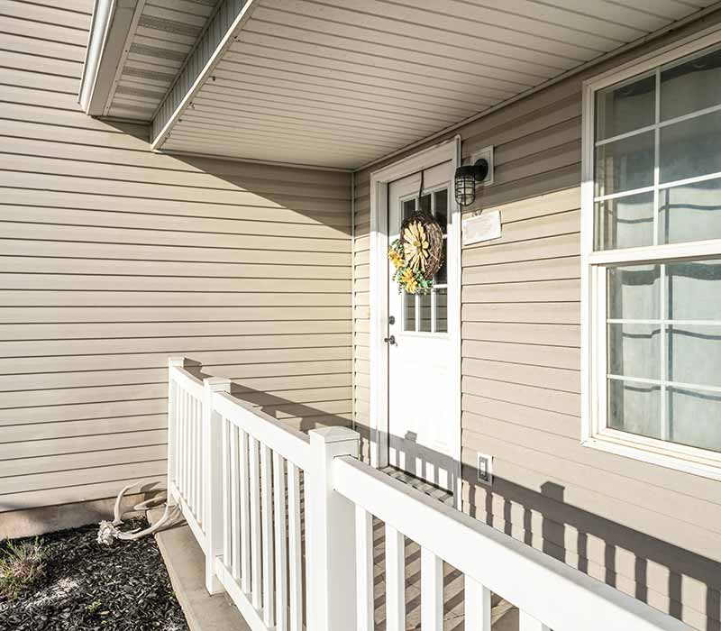 Close up of a front porch of a home with beige siding